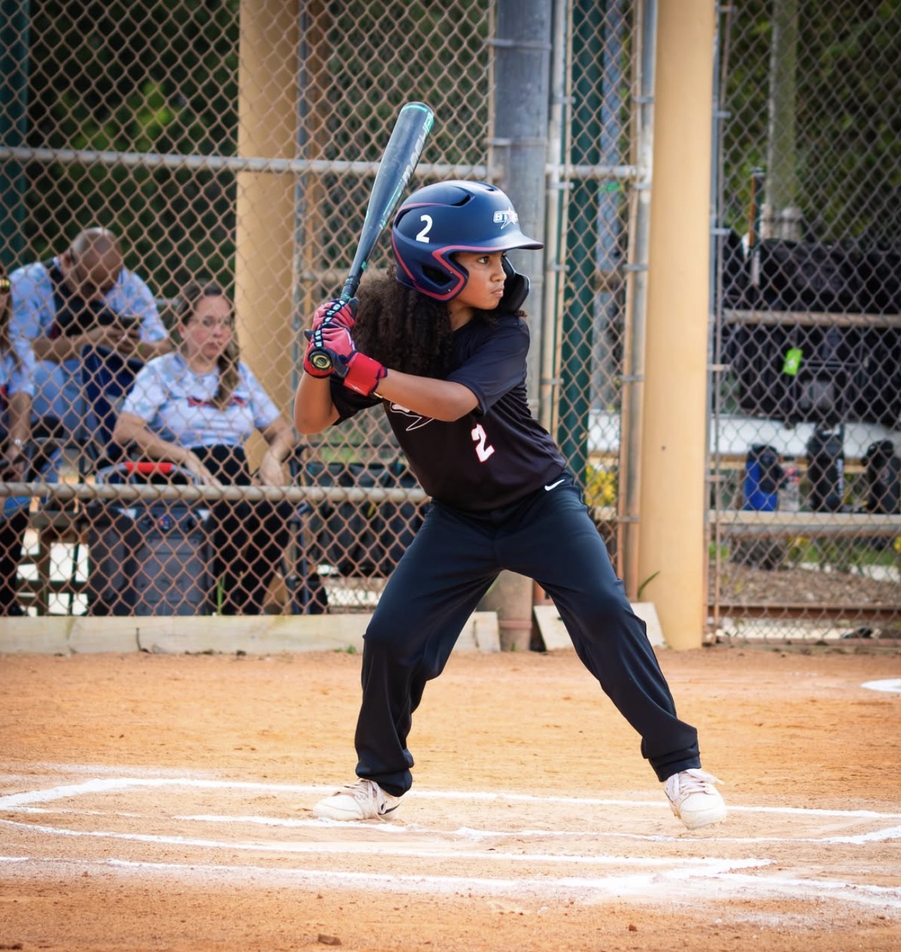 Theo wearing his black baseball uniform at bat